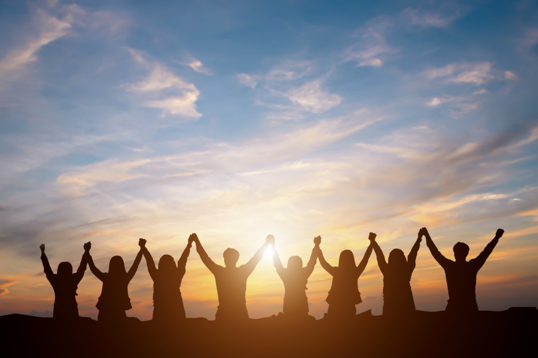 Diverse group of people smiling and walking on a path towards a bright future, symbolizing empowerment and progress